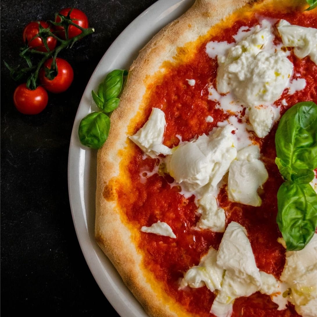 Pizza de Malapizza con tomate, queso y albahaca