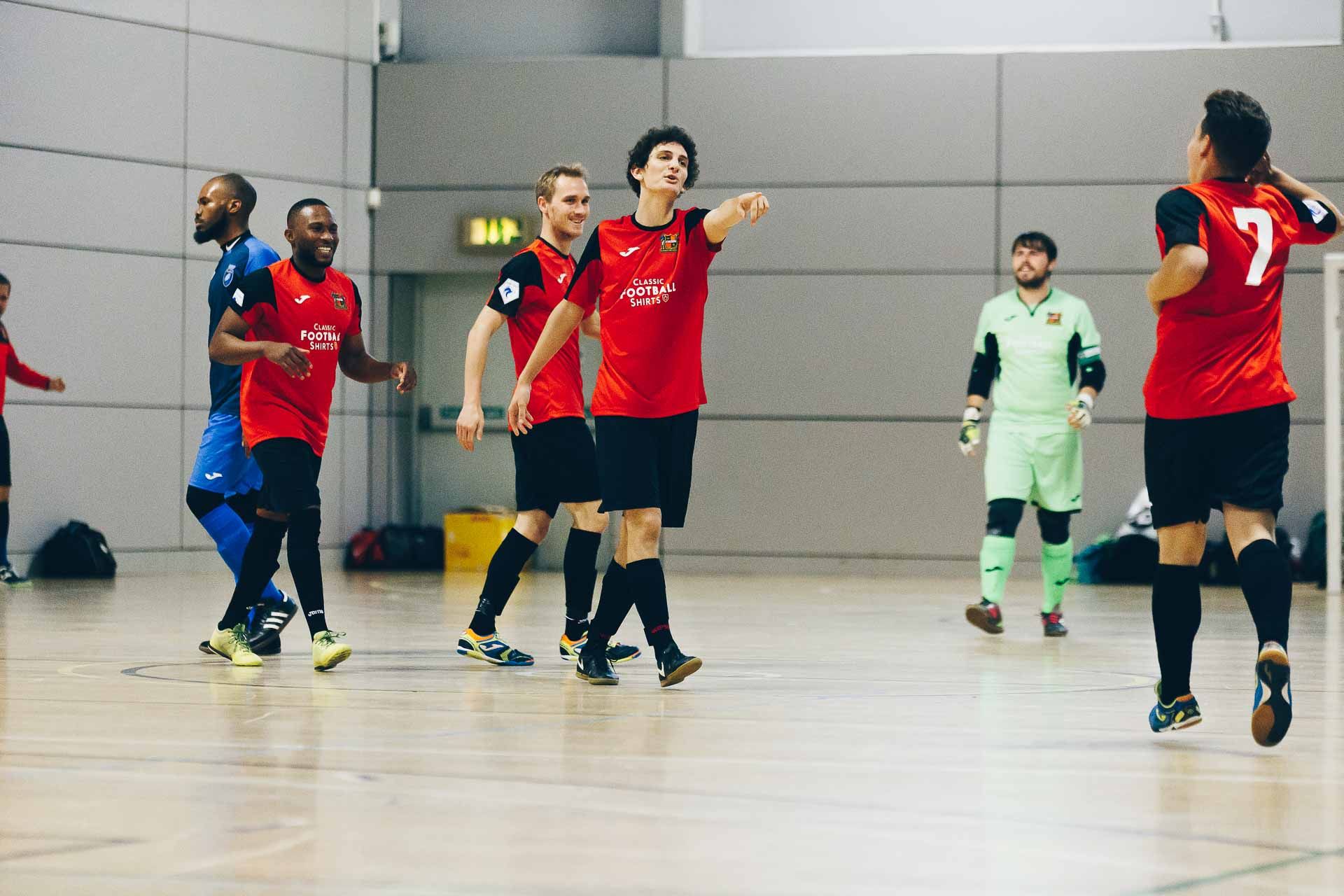 Jugadores disputando un partido de fútbol sala en una pista cubierta